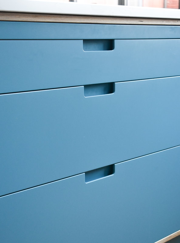 Rebated drawer pulls on sprayed contemporary handmade kitchen in Cround End North London. Birch ply drawers and doors