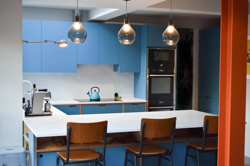 seating bar in sprayed contemporary handmade kitchen in Cround End North London. Birch ply drawers and doors