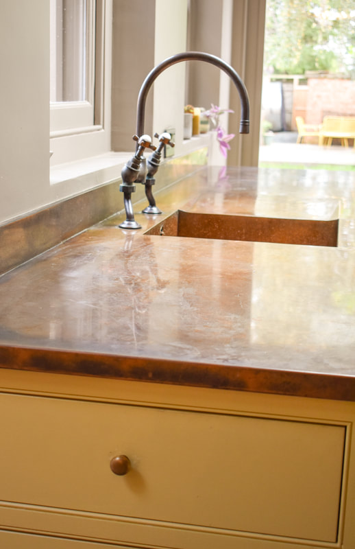Distressed copper worktop on handmade panelled shaker kitchen in Barnet North London