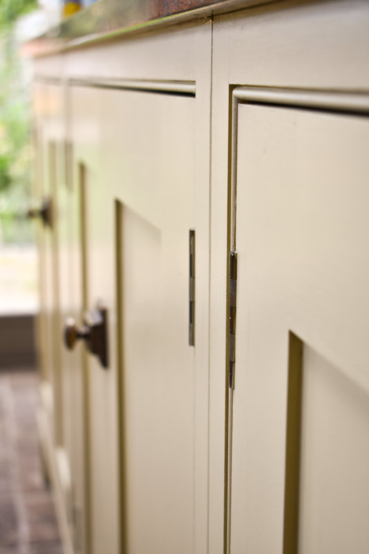 Panelled doors and antique brass knobs on handmade panelled shaker kitchen in Barnet North London