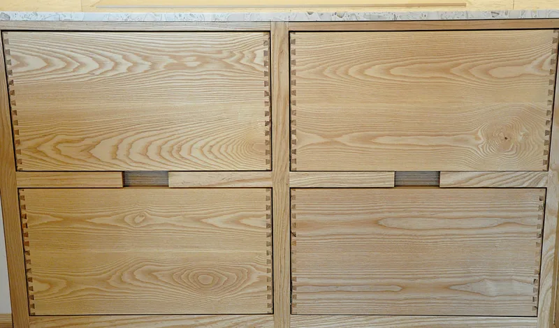Solid ash kitchen in Dulwich London with dovetailed details on drawer fronts. Fluted ash kitchen island with birch ply drawers 