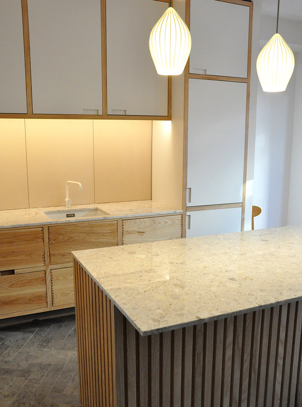 Solid ash kitchen in Dulwich London with dovetailed details on drawer fronts. Fluted ash kitchen island with birch ply drawers 