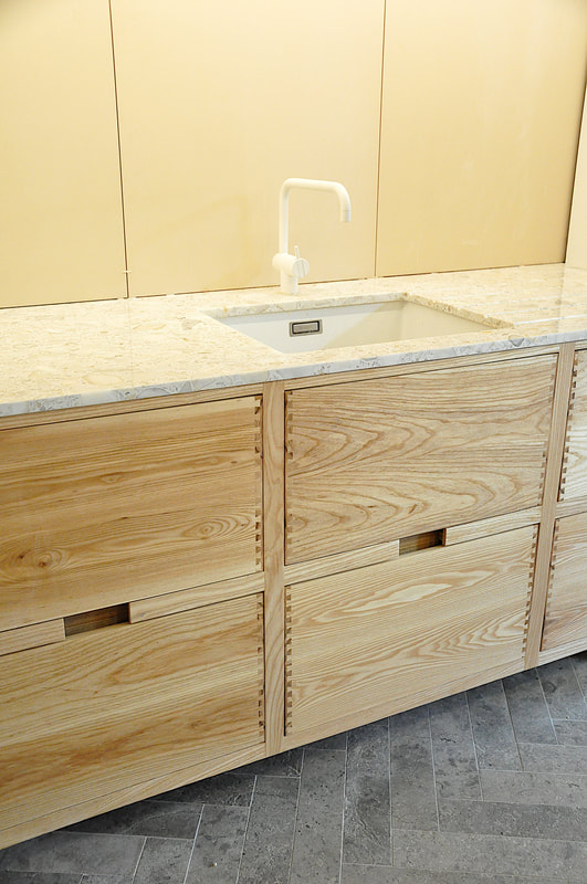 Solid ash kitchen in Dulwich London with dovetailed details on drawer fronts. Fluted ash kitchen island with birch ply drawers 
