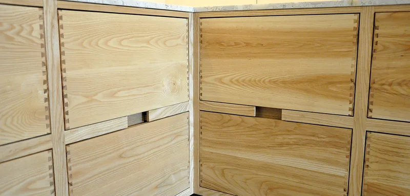 Solid ash kitchen in Dulwich London with dovetailed details on drawer fronts. Fluted ash kitchen island with birch ply drawers 