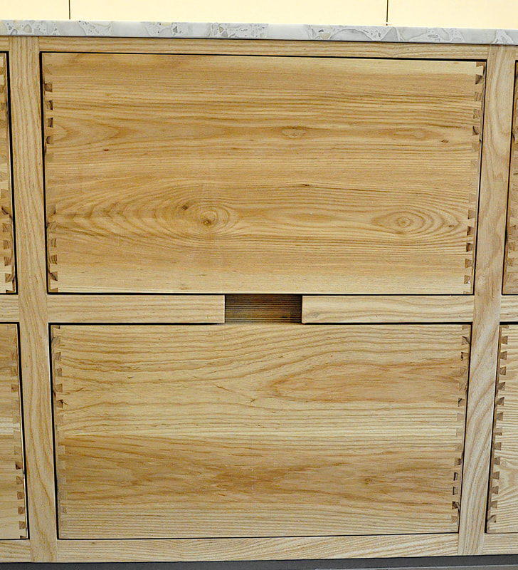 Solid ash kitchen in Dulwich London with dovetailed details on drawer fronts. Fluted ash kitchen island with birch ply drawers 