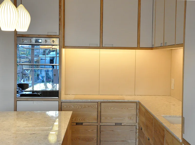 Solid ash kitchen in Dulwich London with dovetailed details on drawer fronts. Fluted ash kitchen island with birch ply drawers 