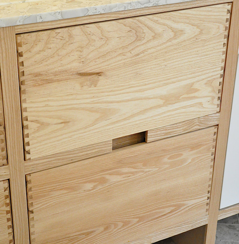 Solid ash kitchen in Dulwich London with dovetailed details on drawer fronts. Fluted ash kitchen island with birch ply drawers 