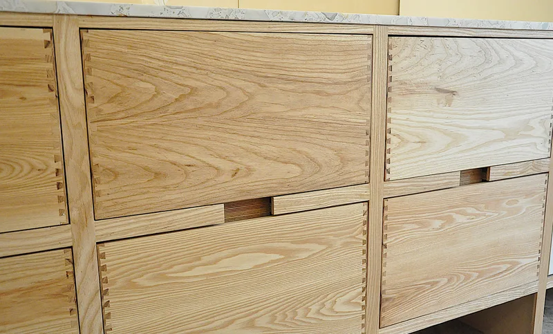 Solid ash kitchen in Dulwich London with dovetailed details on drawer fronts. Fluted ash kitchen island with birch ply drawers 