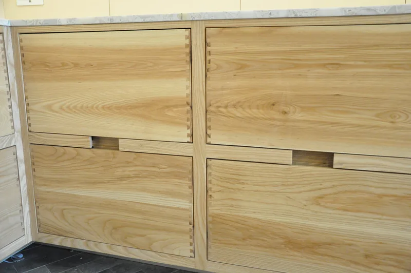 Solid ash kitchen in Dulwich London with dovetailed details on drawer fronts. Fluted ash kitchen island with birch ply drawers 