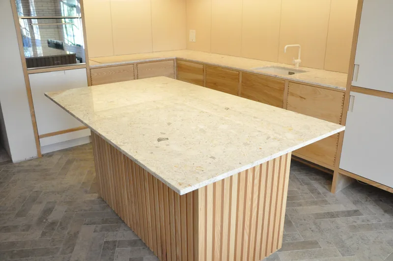 Solid ash kitchen in Dulwich London with dovetailed details on drawer fronts. Fluted ash kitchen island with birch ply drawers 