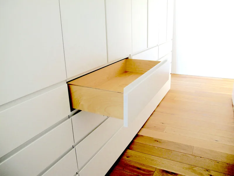 Soft close wardrobe drawers in contemporary studio living space in North London