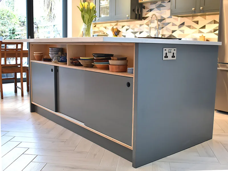 Contemporary mixed materials kitchen in Stroud Green North London finish sprayed with recessed drawer pulls and kitchen island with sliding doors 
