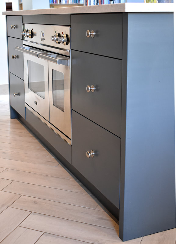 Contemporary mixed materials kitchen in Stroud Green North London finish sprayed with recessed drawer pulls and kitchen island with sliding doors 