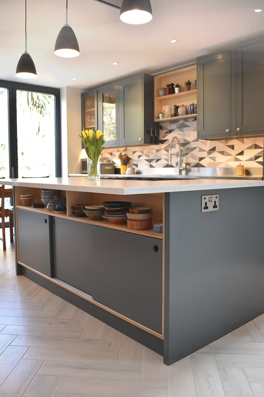 Contemporary mixed materials kitchen in Stroud Green North London finish sprayed with recessed drawer pulls and kitchen island with sliding doors 