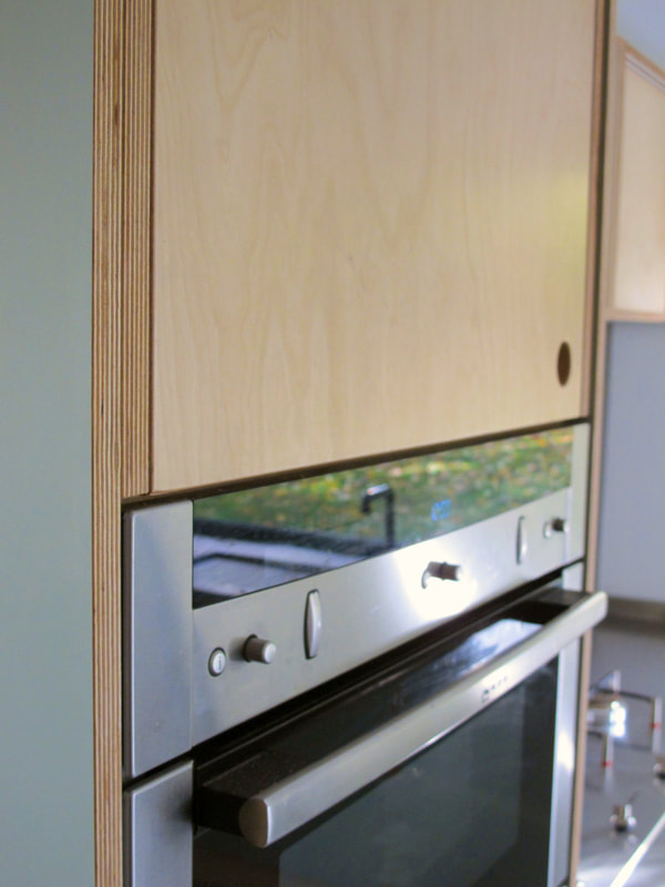 Contemporary formica laminated birch ply kitchen in Saffron Walden Esex with a stainless steel worktop