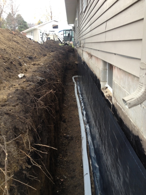 Rubber membrane on block wall with drain tile for waterproofing.