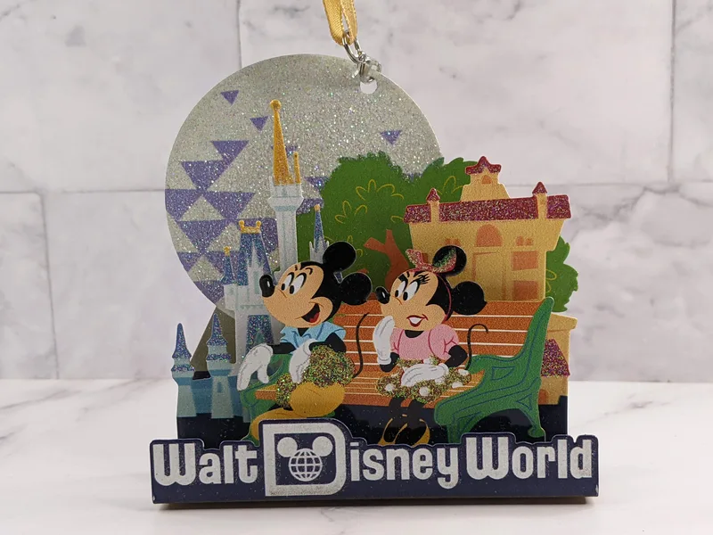 A metal ornament that features Mickey Mouse and Minnie Mouse at Walt Disney World.