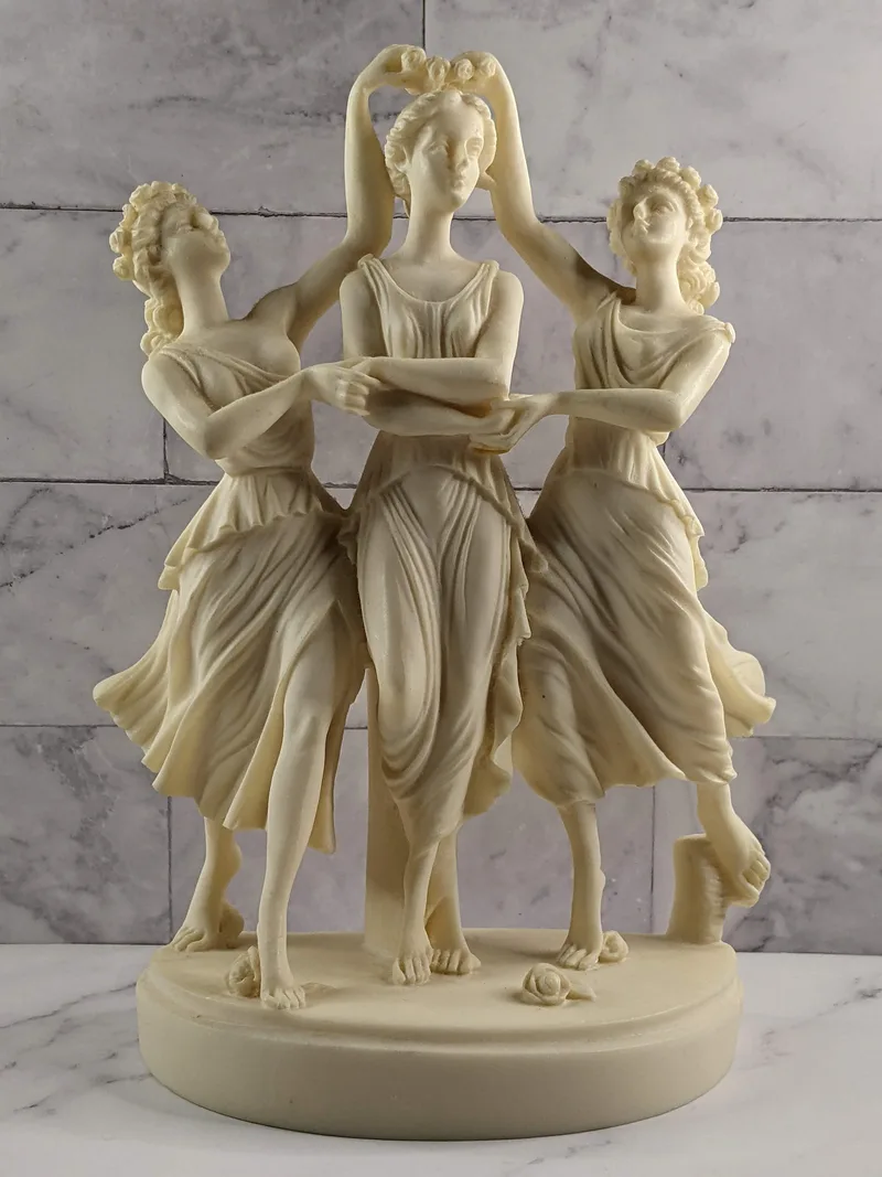 A tabletop sculpture of three dancing women.