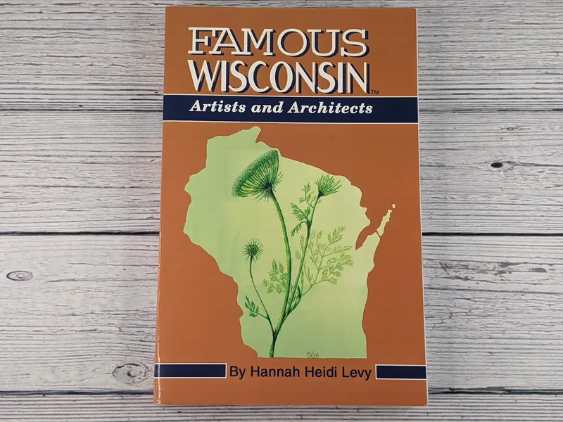 A paperback book with an orange cover that has a green outline of the state of Wisconsin, titled Famous Wisconsin Artists and Architects.