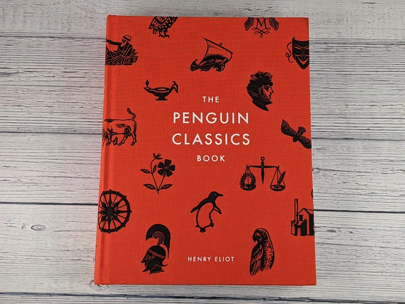 An orange hardcover book titled The Penguin Classics Book by Henry Eliot.