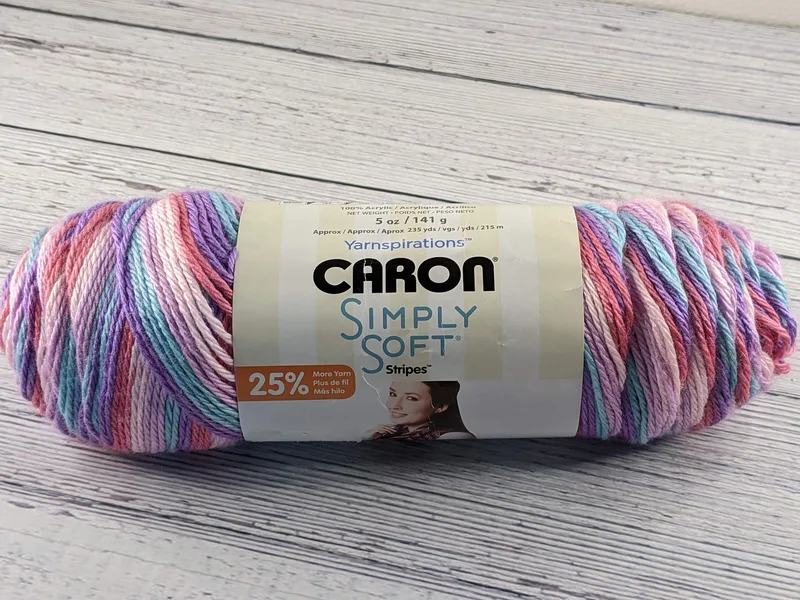 A skein of yarn that is aqua, pink, and purple.