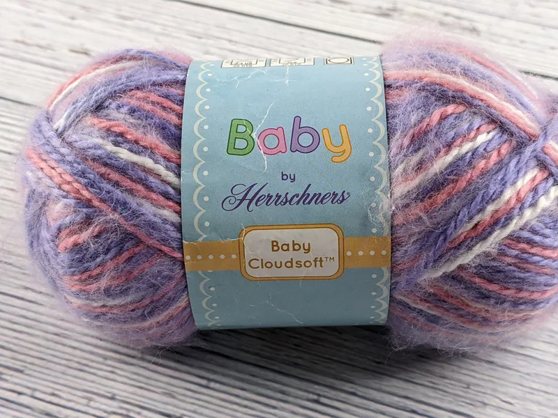 Soft pastel skein of yarn in white, pink and purple.