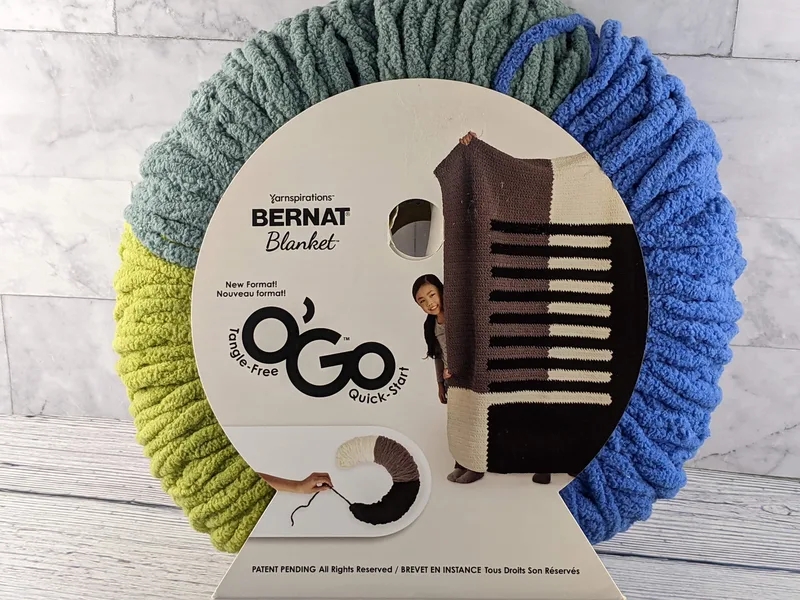 A round wrap of green and blue blanket yarn.