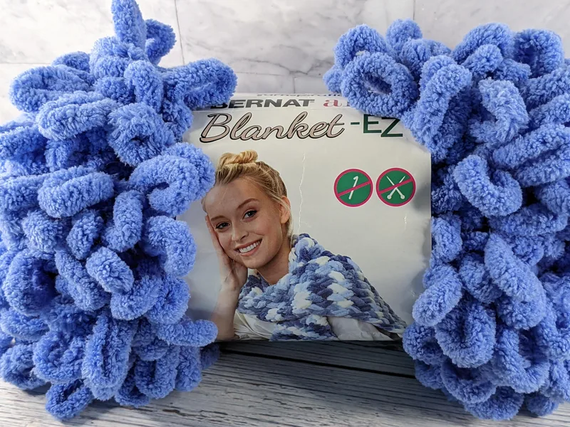 A medium blue blanket yarn that is soft and loopy.