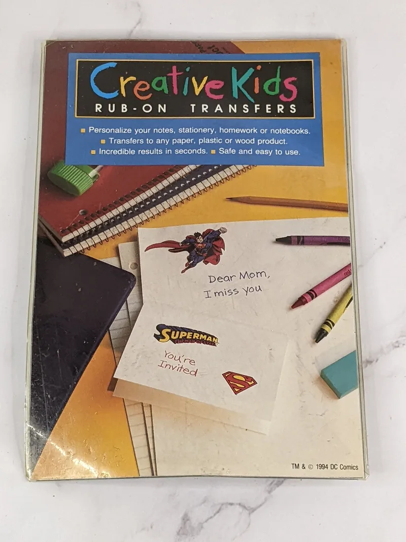 A vintage sheet of rub-on transfers with a Superman design from 1994.