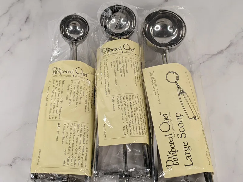A set of Pampered Chef scoops in three sizes. It includes small, medium and large scooping baking utensils