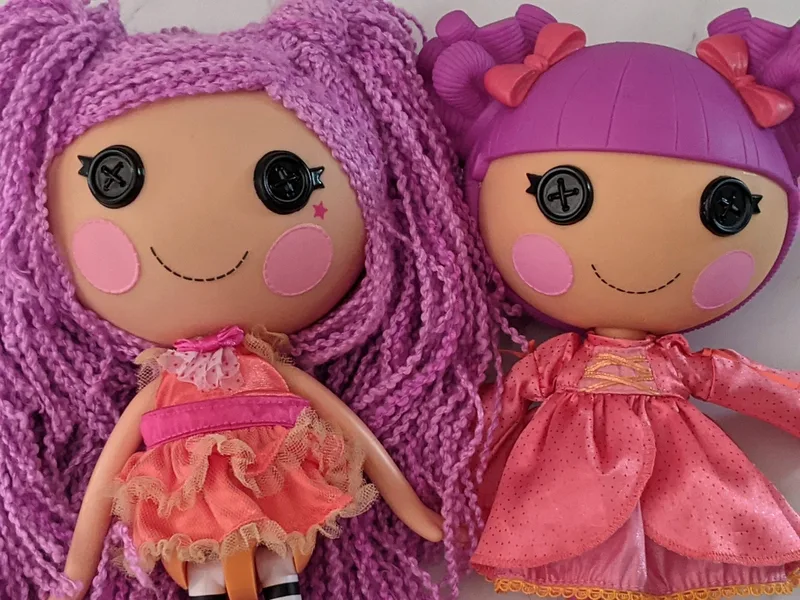 Two toy dolls with purple hair by Lalaloopsy: Loopy Hair Peanut Big Top doll and Lady Stillwaiting doll.