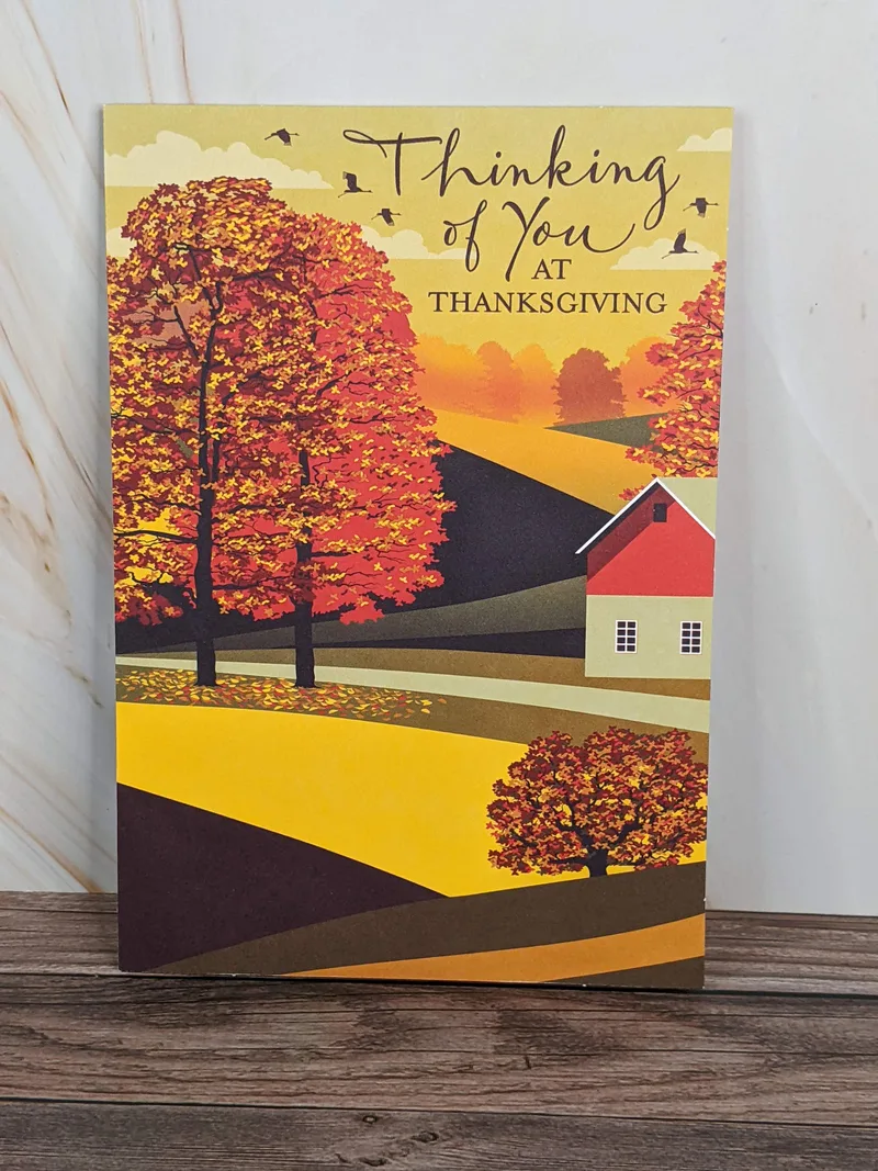 A Thanksgiving card with an image of autumn trees near a house.