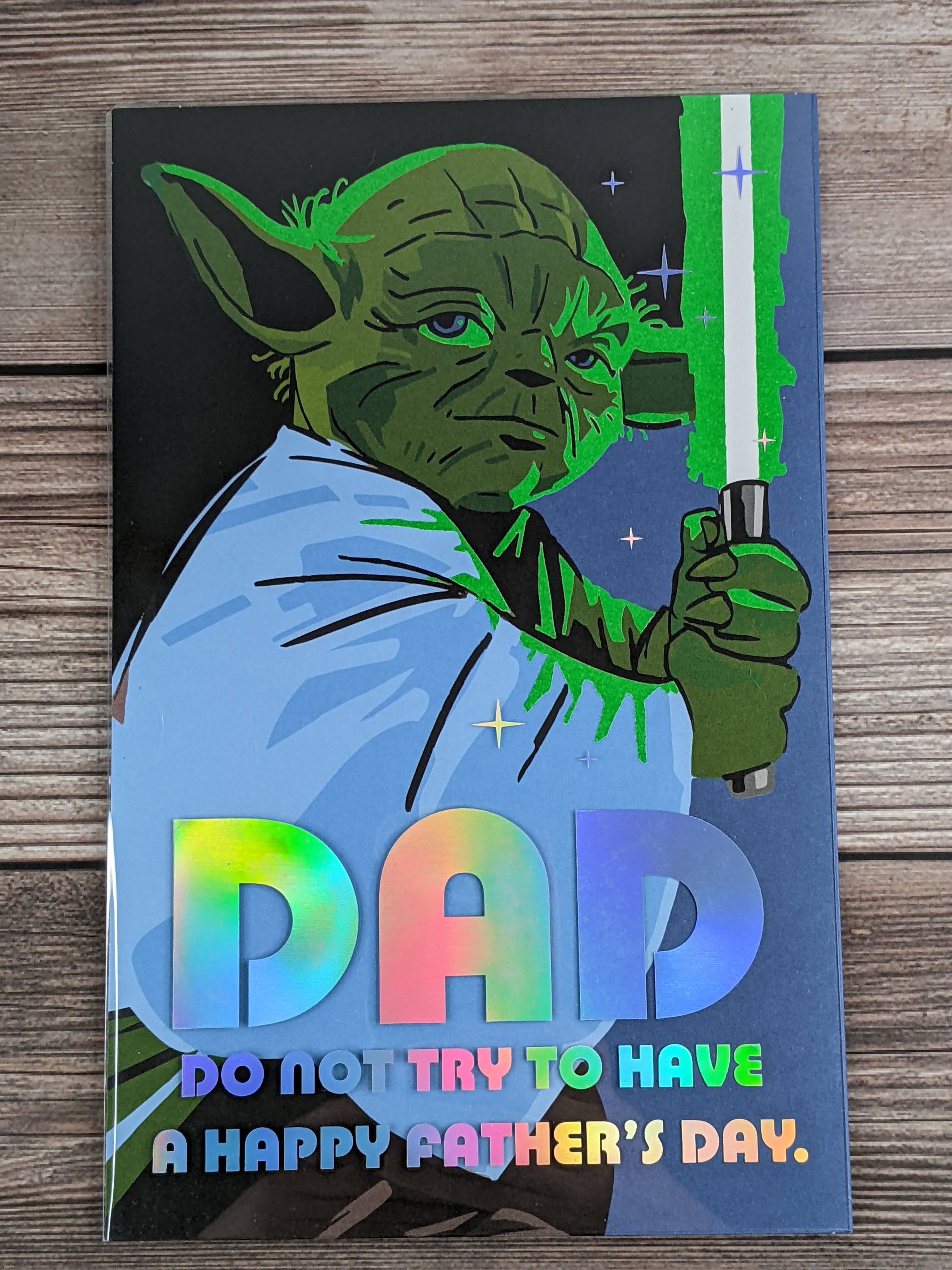 A Disney Star Wars Father's Day greeting card with a shiny cover that features an image of Yoda and reflective lettering.