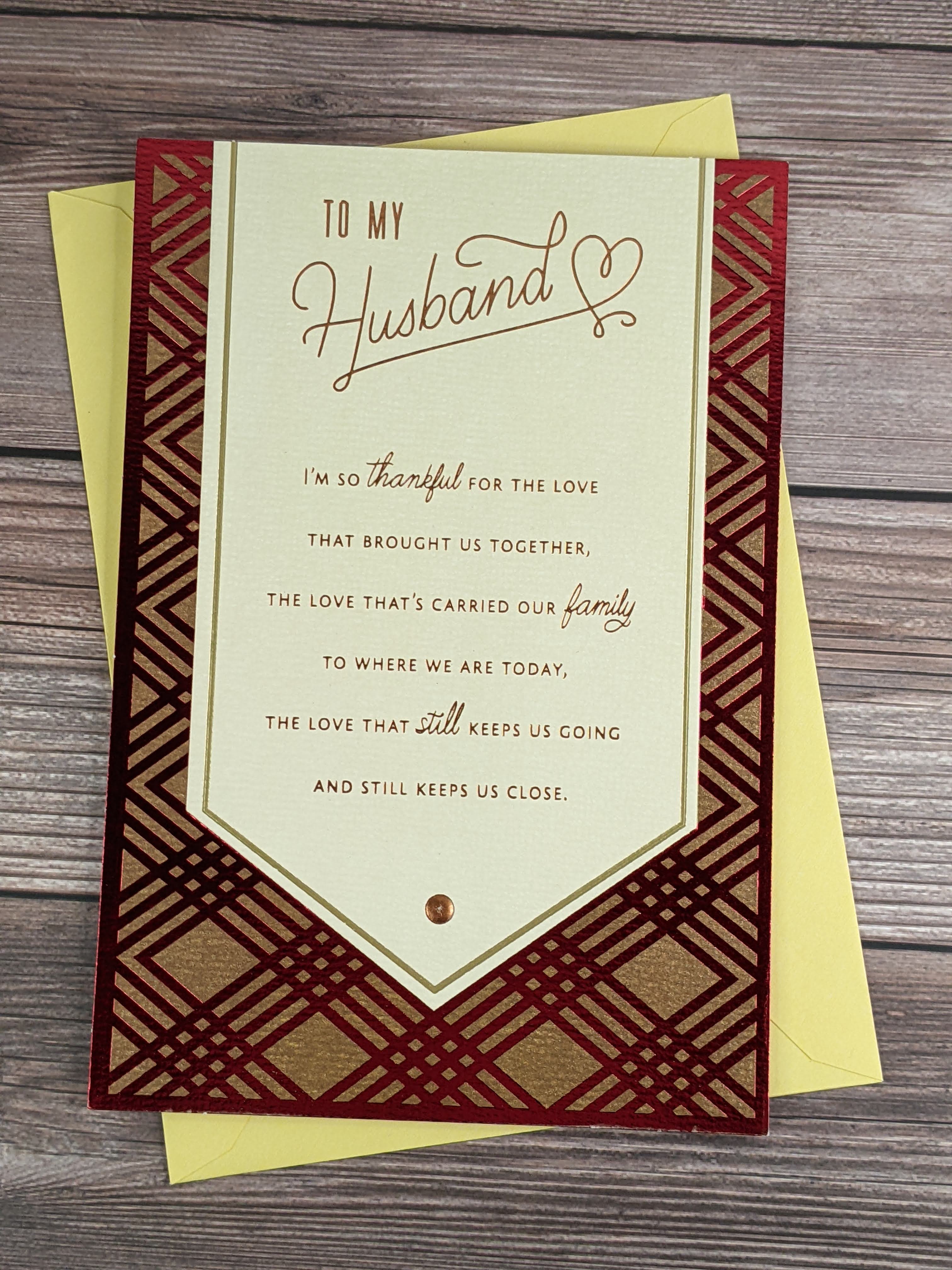 A Hallmark Father's Day greeting card for a husband, with a tan and metallic-red plaid cover.