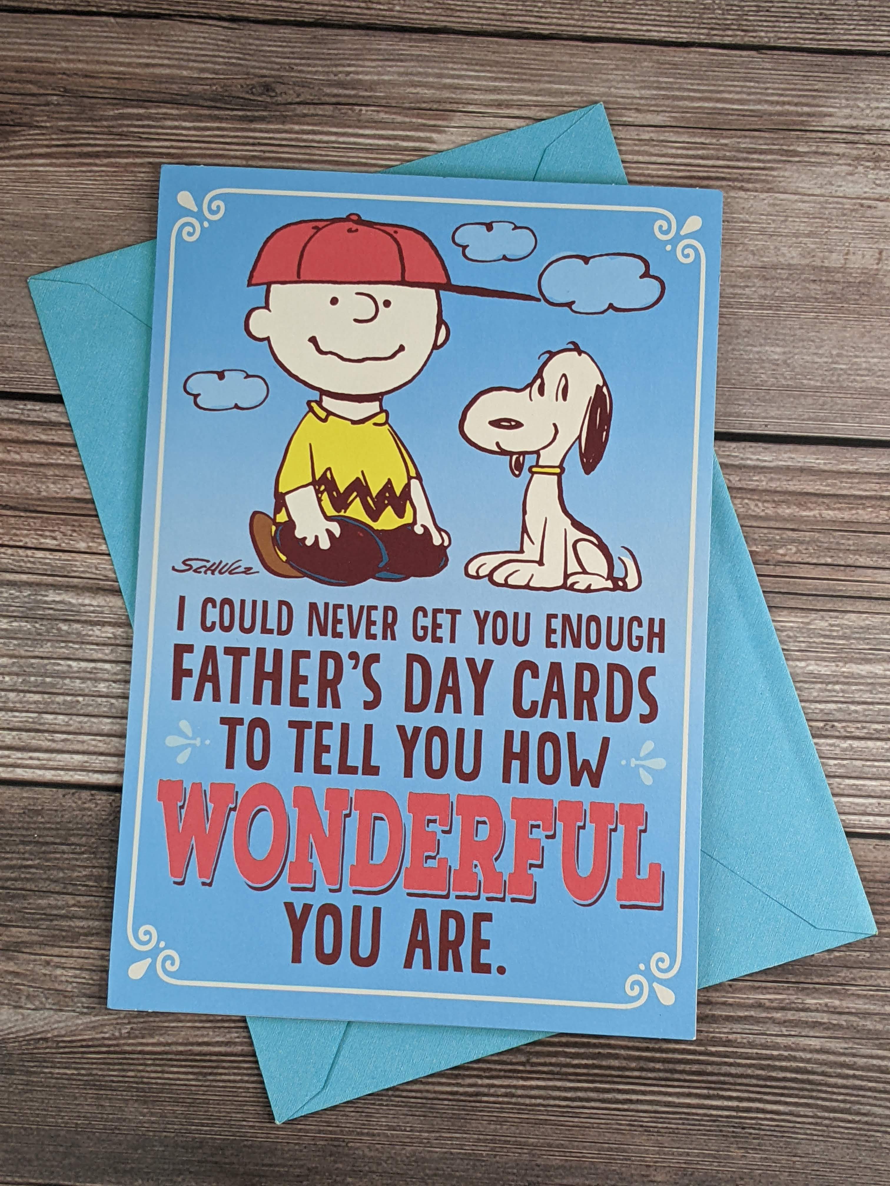 A Peanuts-characters themed blue Father's Day greeting card with Charlie Brown and Snoopy on the cover.