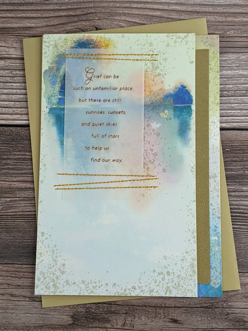 A premium sympathy greeting card with a watercolor design and golden thread stitches.