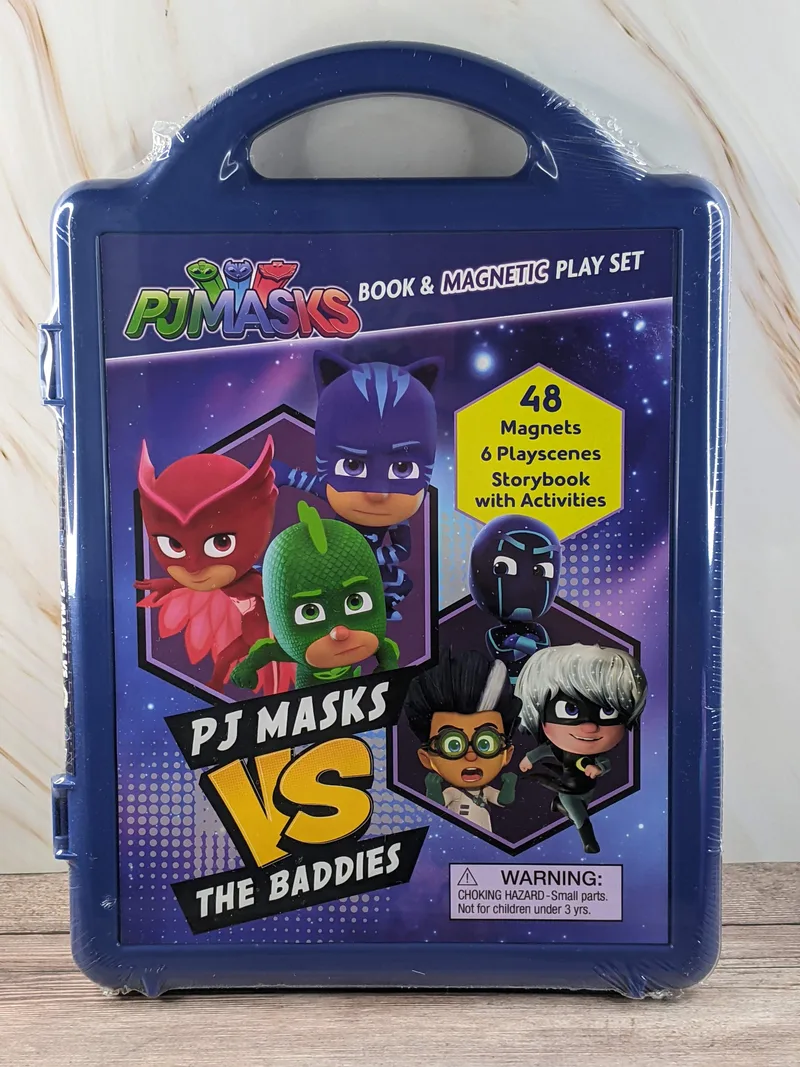 A blue plastic carrying case with images of PJ Masks characters on the front with a book and magnetic play set inside.