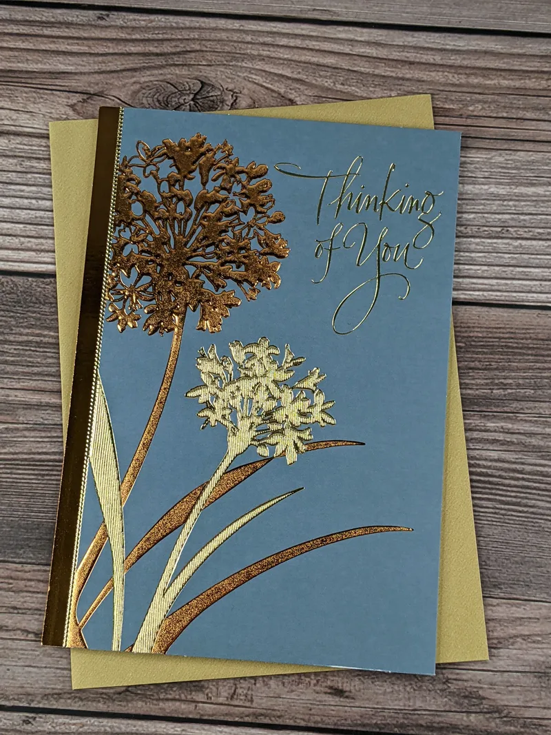 A blue "cope" greeting card with images of metallic gold and copper flowers.