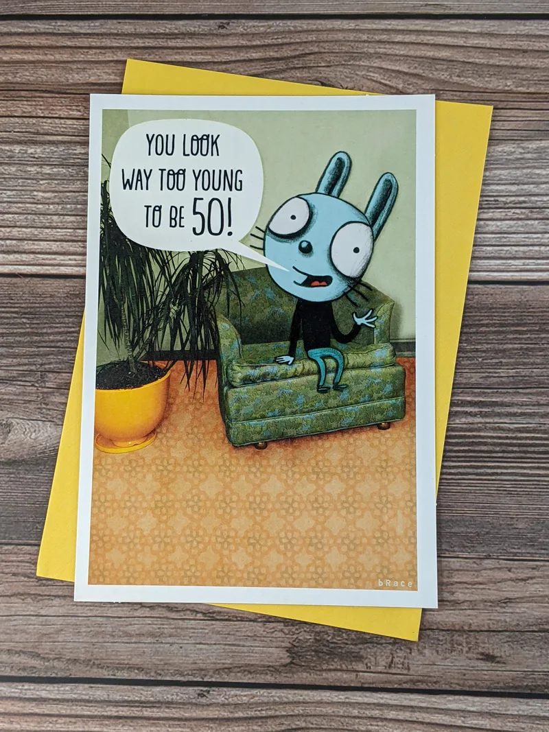 A greeting card with an image of a blue cartoon drawing of a bunny saying a 50th birthday greeting.