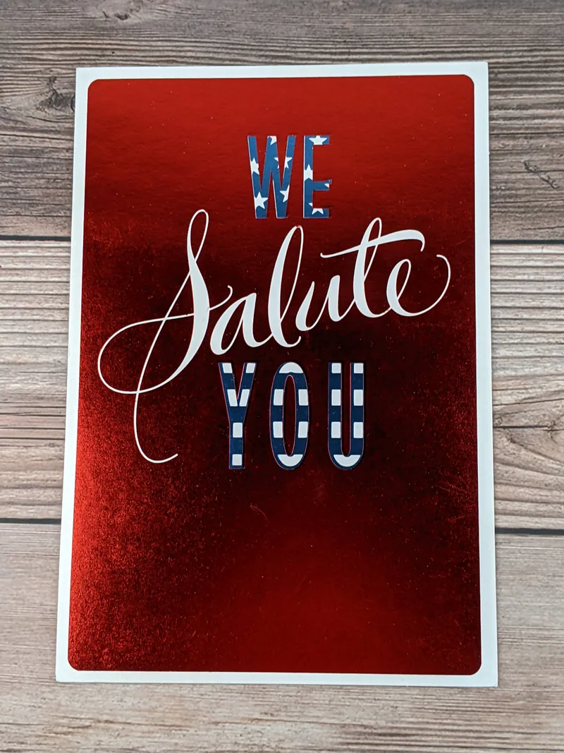 A metallic red greeting card with the words We Salute You for Veteran's Day.