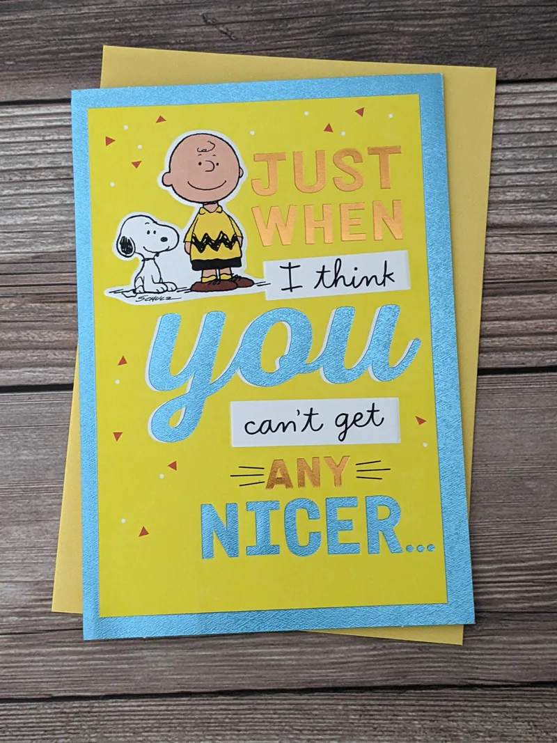 A thank-you greeting card that is yellow with an image of Snoopy and Charlie Brown.