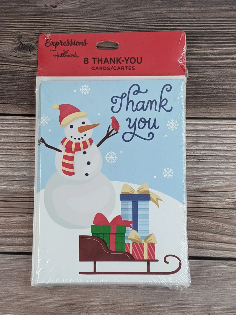 A value pack of Christmas thank you cards with an image of a snowman near a sled of gifts.