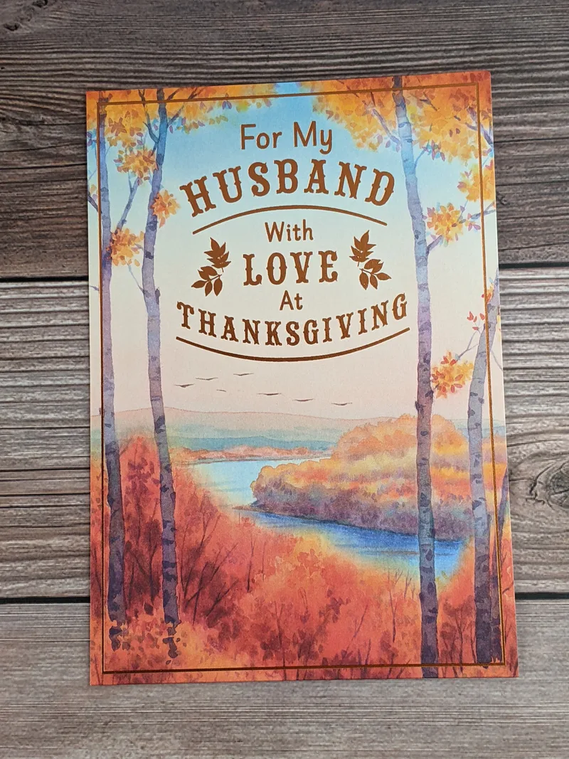 A thanksgiving card for a husband with an image of autumn trees near a lake.