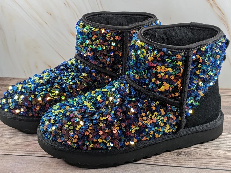 A pair of black sequin-covered women's boots, size 7 by UGG.