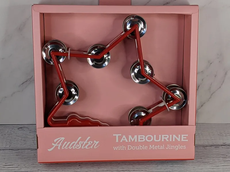 A red star shaped tambourine with silver jingles.
