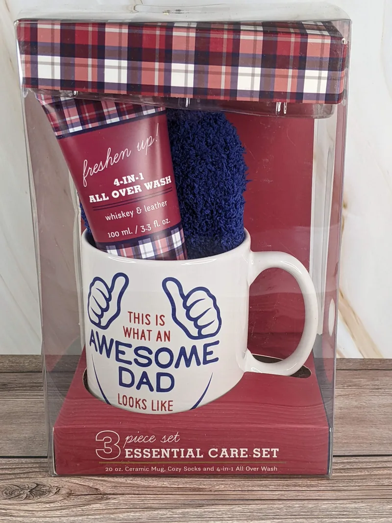 A white ceramic mug with the words, "this is what an awesome dad looks like" with a pair of socks and body wash.