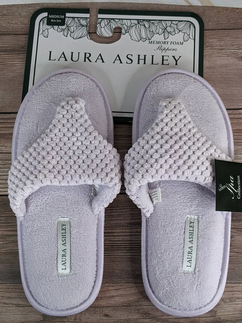 A pair of lavender memory foam slippers for women that are flip-flop style.