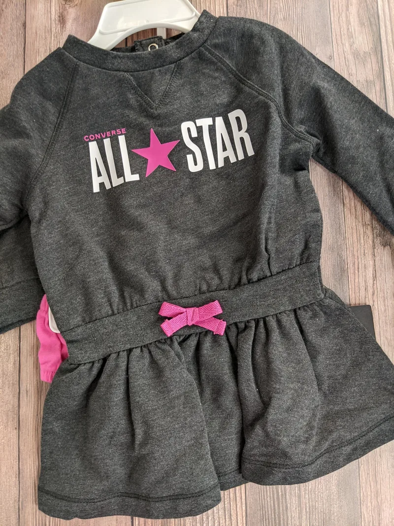 A dark gray ruffle romper for a baby girl, with an all-star design by Converse. 