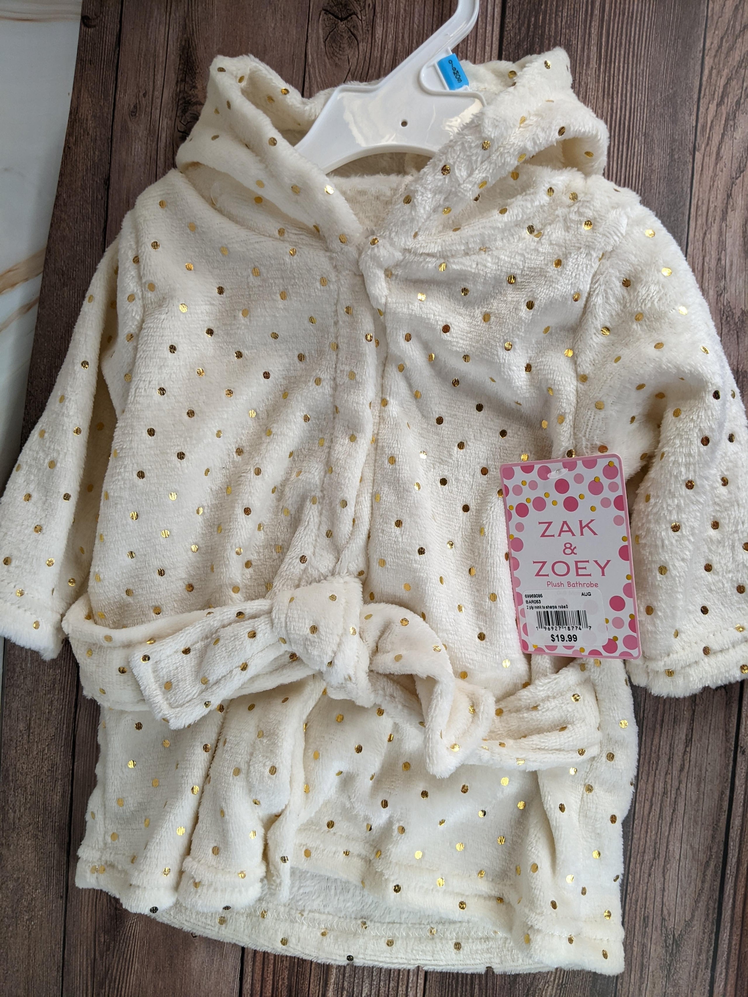 This cute baby bathrobe is soft cream shade with a design pattern of gold polka dots! 