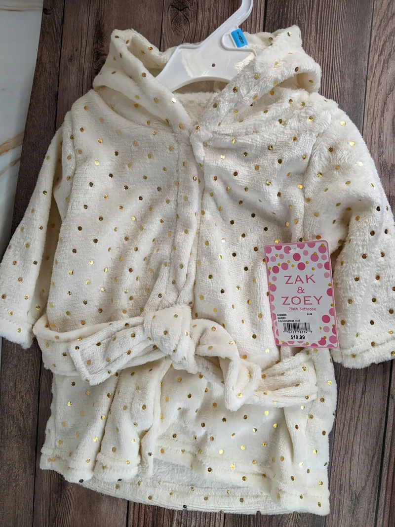 This cute baby bathrobe is soft cream shade with a design pattern of gold polka dots! 
